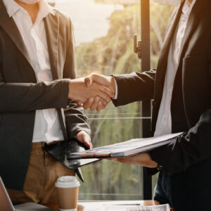 Business handshake closing a deal with blur background of people.